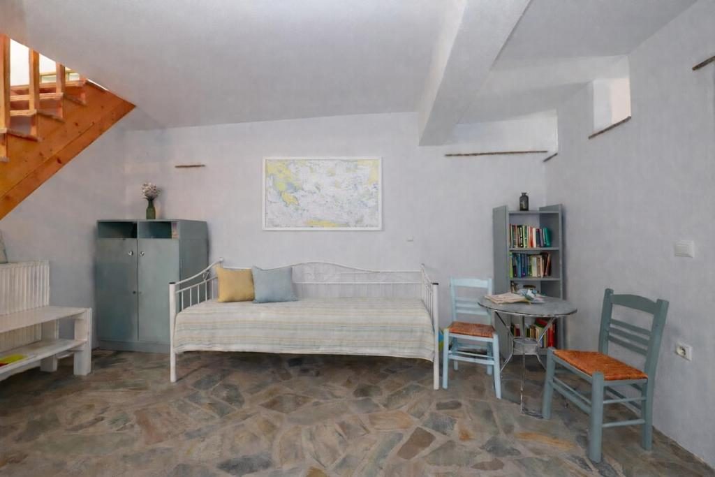 Open area with sofa bed, stone floor and bookshelf